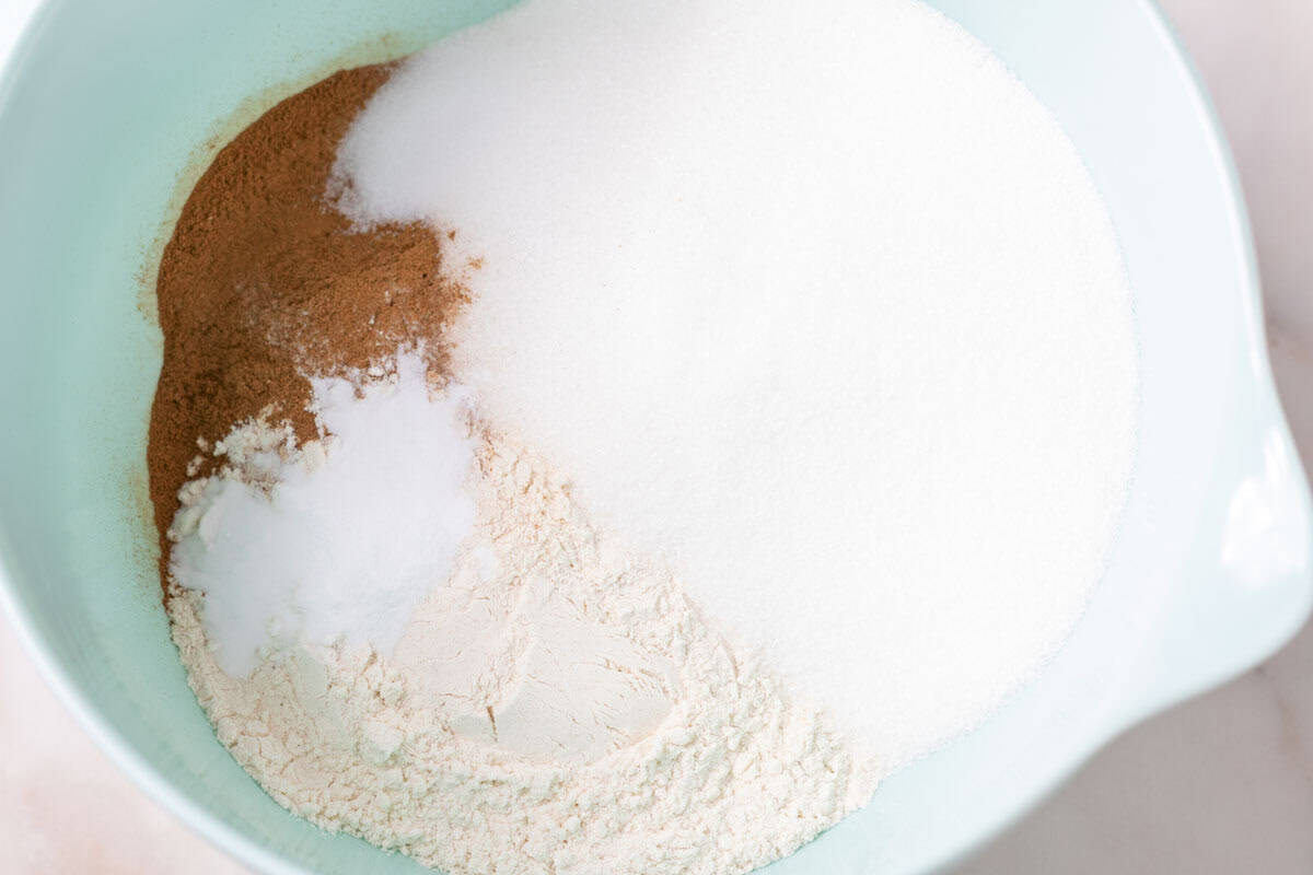 Carrot Cake Loaf Cake | thewendthousekitchen.com A light turquoise mixing bowl with flour, cinnamon, sugar, baking soda and salt.