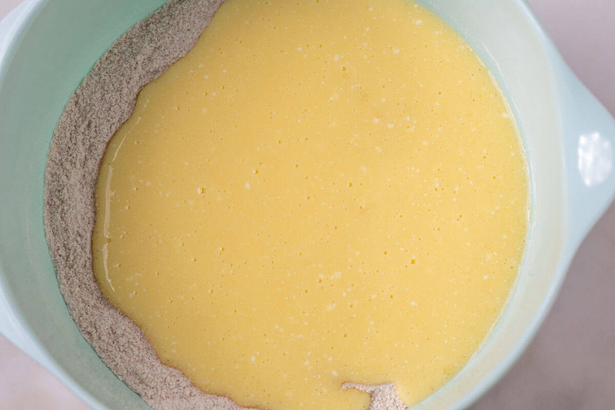 Carrot Cake Loaf Cake | thewendthousekitchen.com Wet ingredients added to dry ingredients in a large mixing bowl.