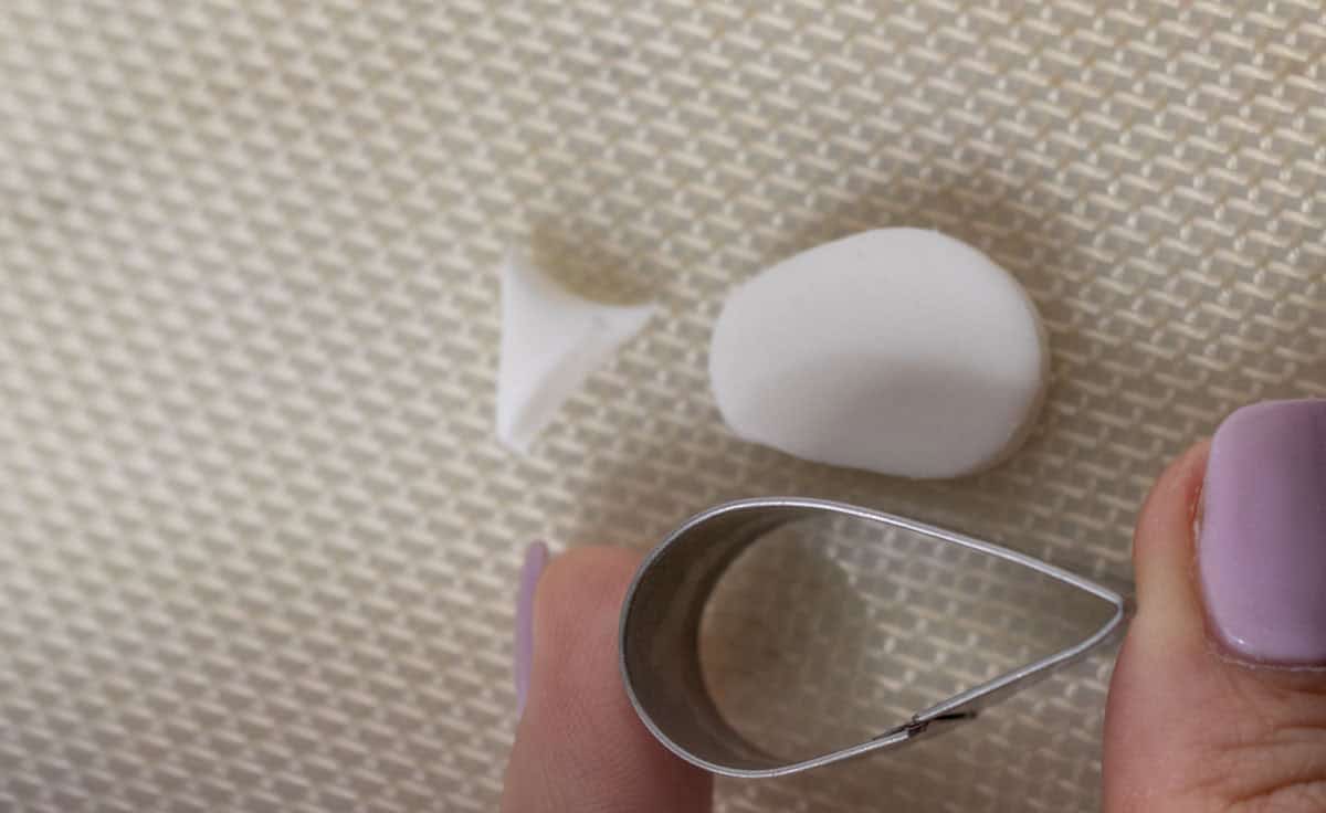 Bunny Cupcakes for Easter (Bunny Butt Cupcakes) | thewendthousekitchen.com A teardrop cutter next to a small piece of white fondant in the shape of a bunny foot.