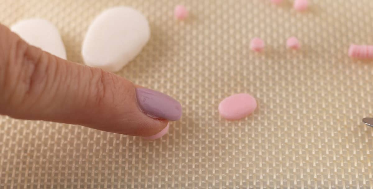Bunny Cupcakes for Easter (Bunny Butt Cupcakes) | thewendthousekitchen.com Pressing down on a round piece of pink fondant cut out.