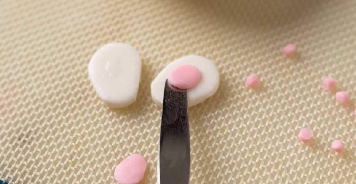 Bunny Cupcakes for Easter (Bunny Butt Cupcakes) | thewendthousekitche.com Moving a pink paw pad onto the bunny paw with a small spatula.