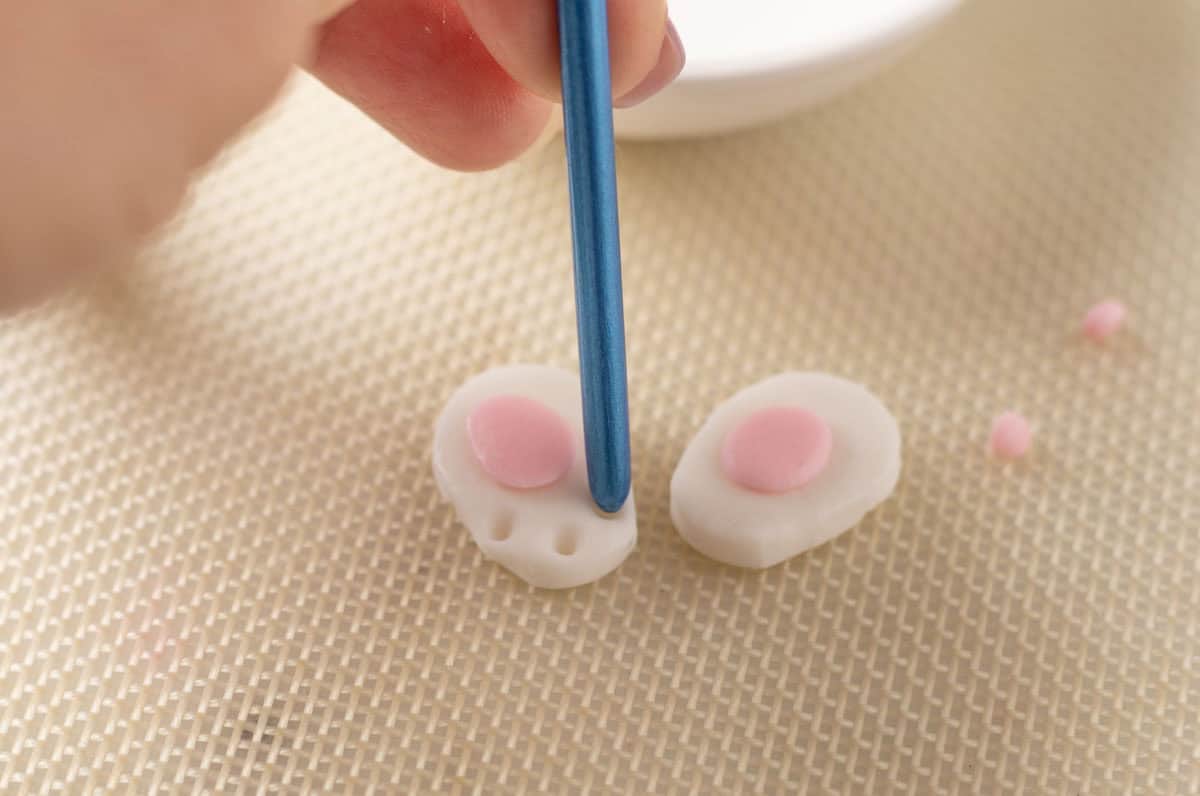 Bunny Cupcakes for Easter (Bunny Butt Cupcakes) | thewendthousekitche.com Using the end of a small paint brush to make holes onto the white bunny paws for small paw pads.