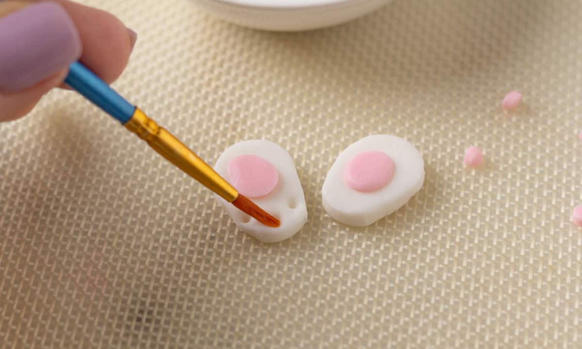 Bunny Cupcakes for Easter (Bunny Butt Cupcakes) | thewendthousekitche.com Using a small paint brush to paint water onto the holes of the bunny pad.