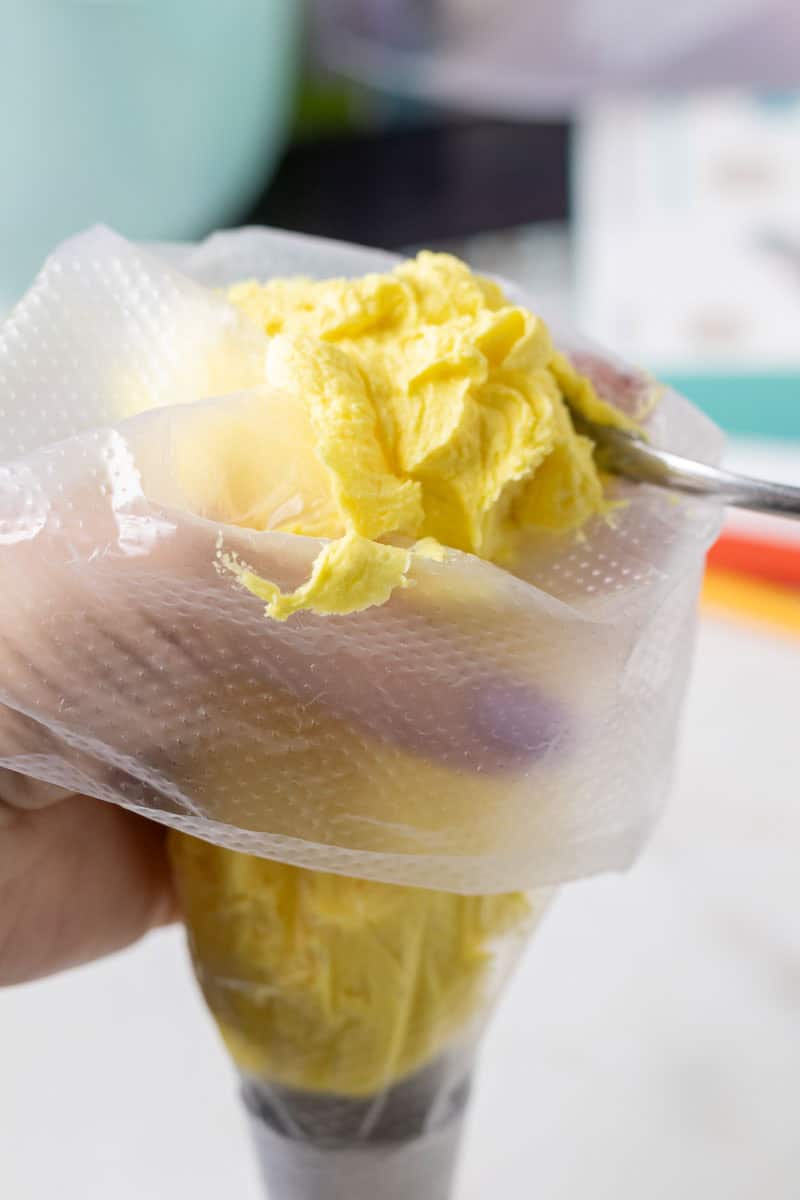 Bunny Cupcakes for Easter (Bunny Butt Cupcakes) | thewendthousekitchen.com Filling a piping bag with yellow buttercream.