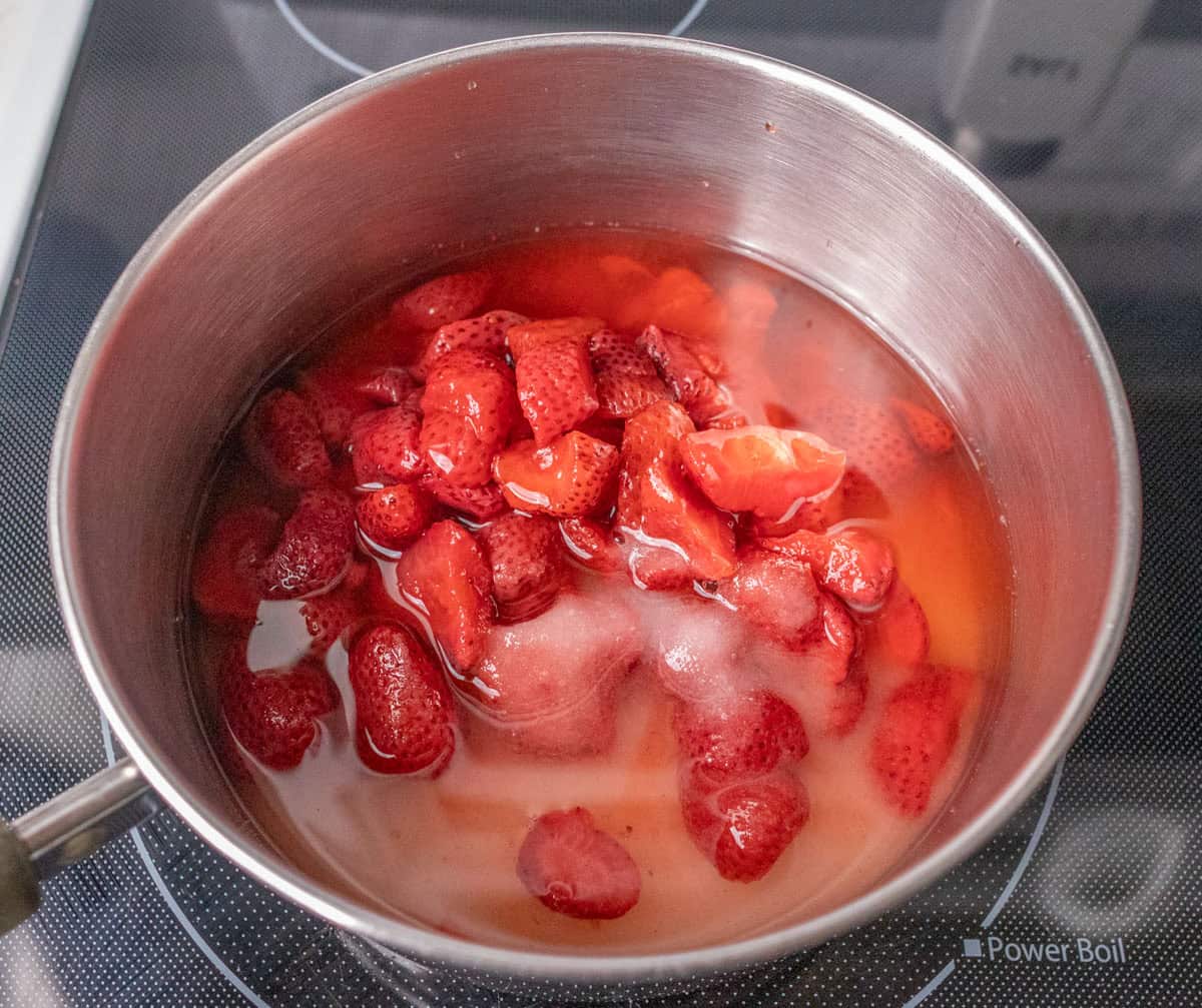 How To Make Strawberry Sauce | thewendthousekitchen.com Strawberries, water and sugar added to a medium saucepan.