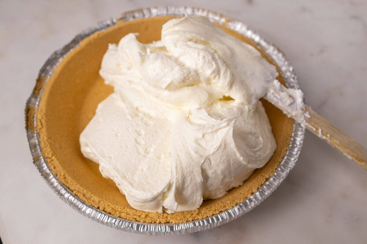 3 Ingredient No Bake Cheesecake | thewendthousekitchen.com Pouring cheesecake filling into a premade graham cracker pie shell.