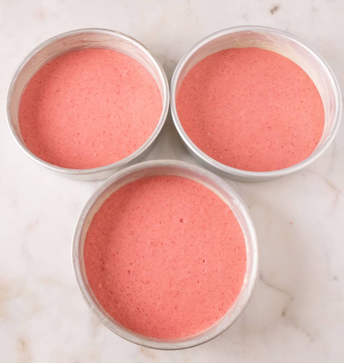 Strawberry Crunch Cake | thewendthousekitchen.com Strawberry cake batter added to three 8-inch, round cake pans.