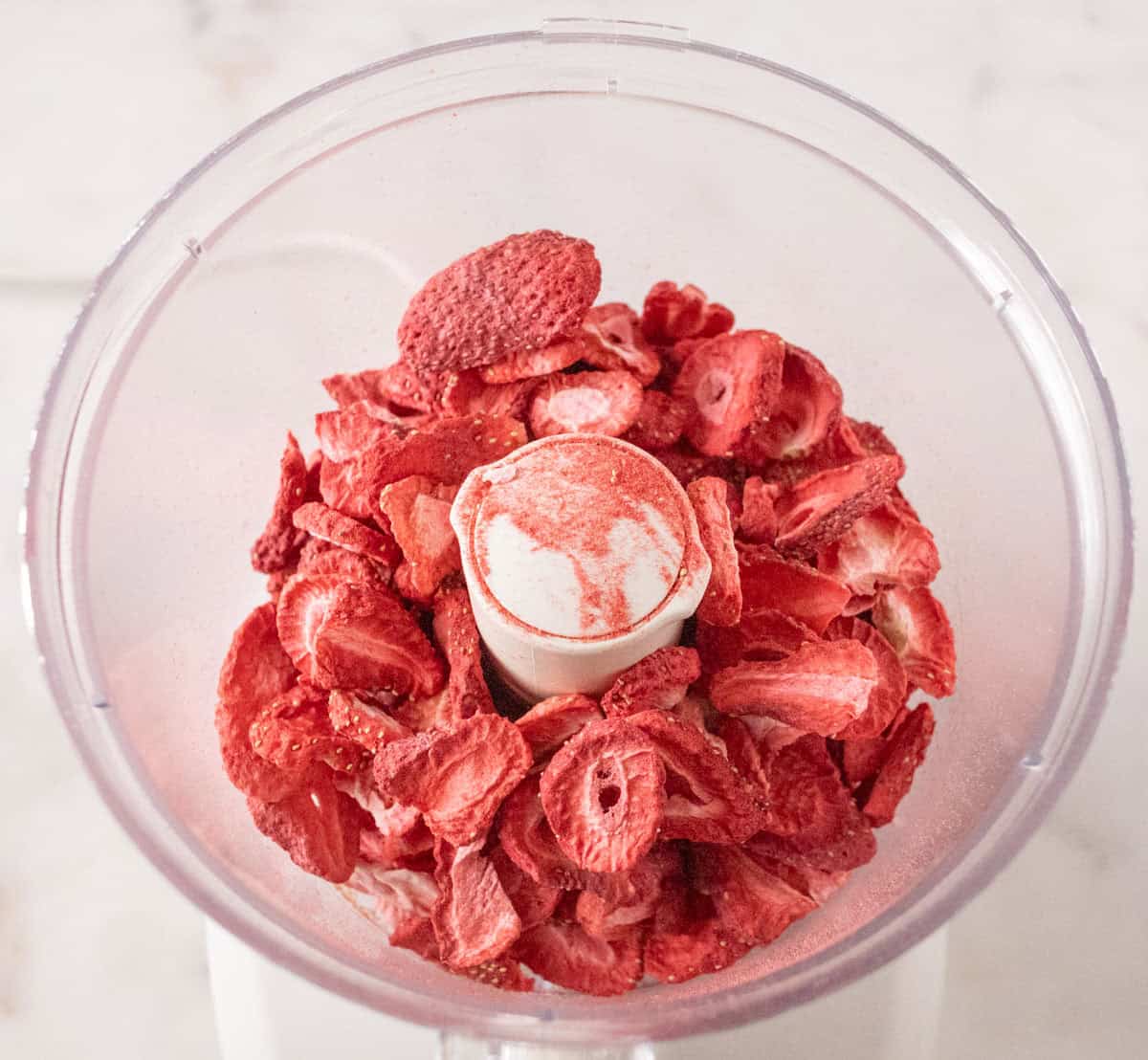 Strawberry Crunch Cake | thewendthousekitchen.com Freeze-dried strawberries inside of a food processor.