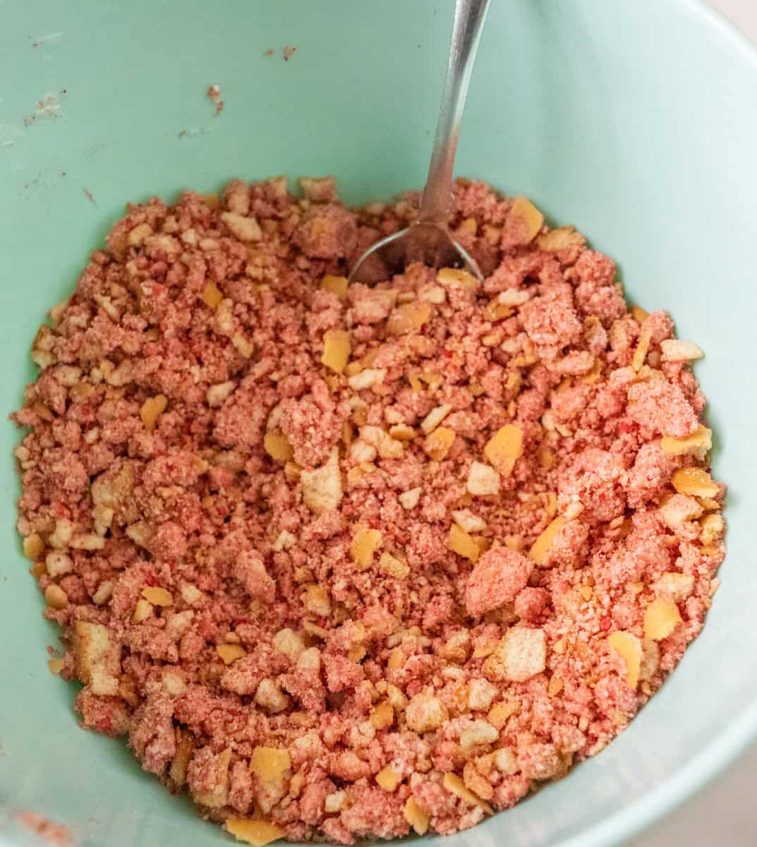 Strawberry Crunch Cake | thewendthousekitchen.com Vanilla wafers, strawberry powder, salt and melted white chocolate mixed together in a mixing bowl.