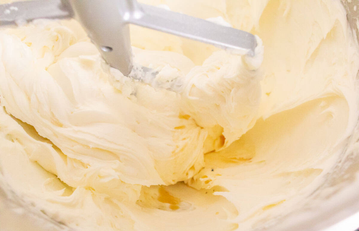 Strawberry Crunch Cake | thewendthousekitchen.com Buttercream in the bowl of a stand mixer with a paddle attachment.