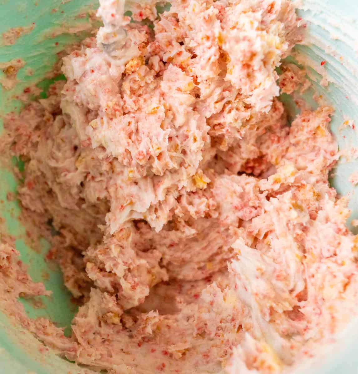 Strawberry Crunch Cake | thewendthousekitchen.com Strawberry crunchies and buttercream mixed together in a medium mixing bowl.
