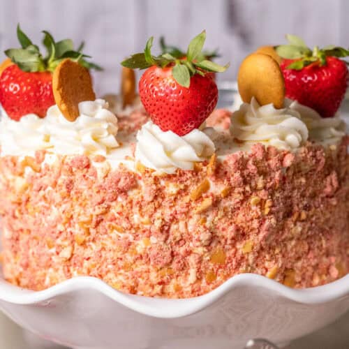 A close-up of Strawberry crunch cake on a white pedestal cake plate.